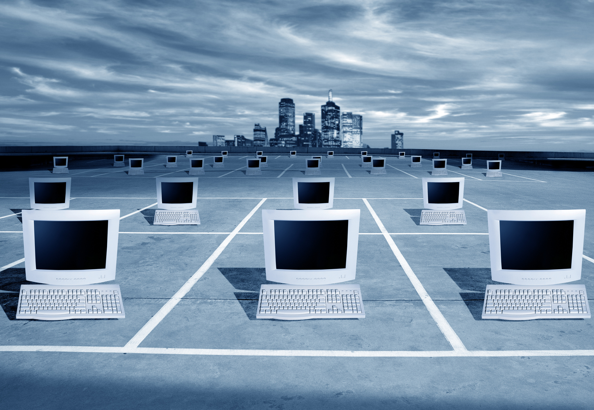 E-COMMERCE, COMPUTERS AND CITY SKYLINE PCs on a grid in front of a city skyline.