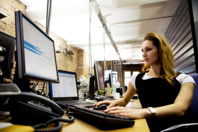 modern workplace: female professional computer programmer working at her desk