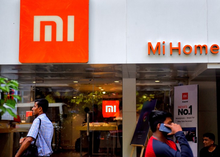 People are seen walking past an MI home mobile store in