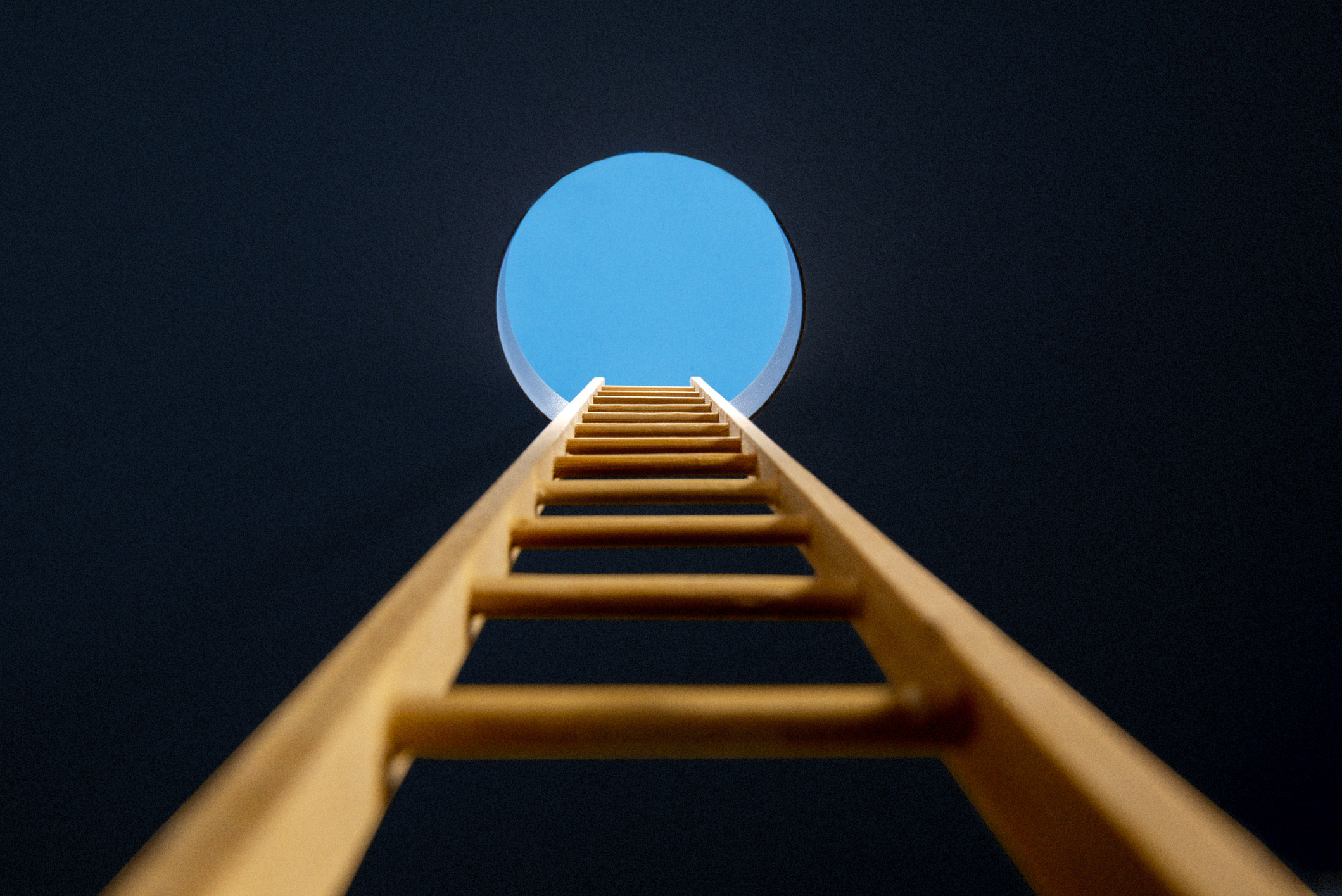 Point of view, looking up ladder sticking through hole in ceiling revealing blue sky
