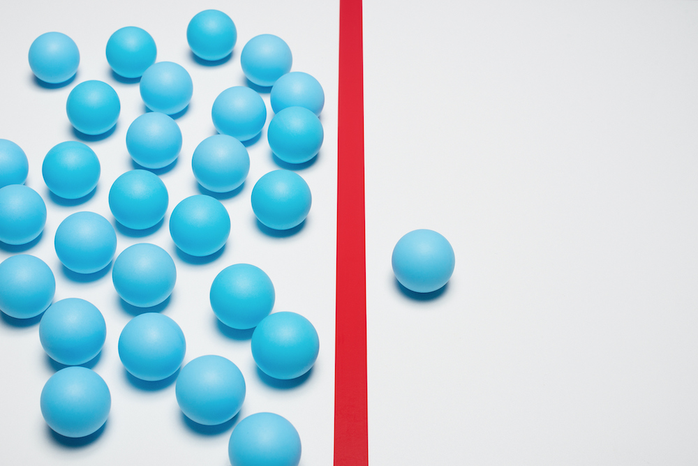 One blue ball on one right side of red line, many blue balls on left side